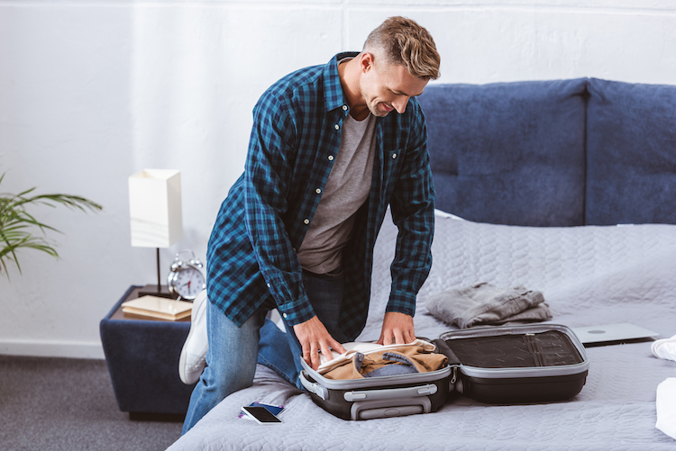 man packing suitcase